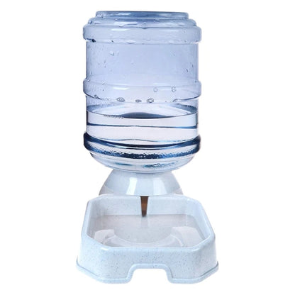 A pet water fountain with a clear plastic water bottle mounted on a white plastic base and a matching white shallow water bowl, shown against a plain white background.