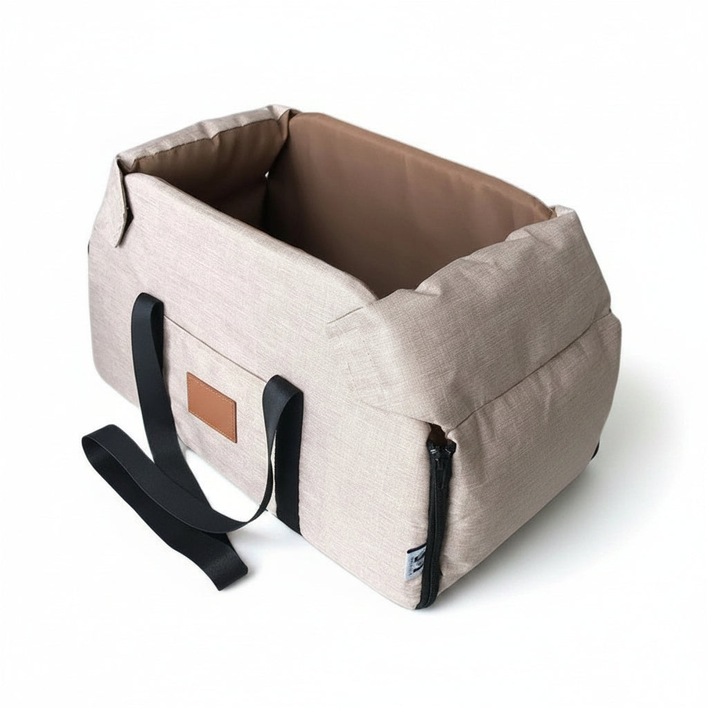 Beige pet carrier with black straps on a white background